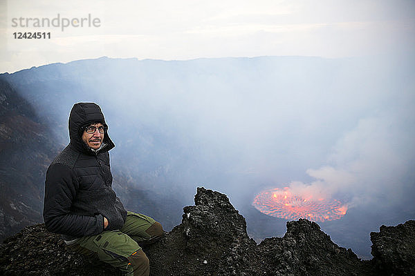 Africa  Democratic Republic of Congo  Virunga National Park  Man sittiing over Nyiragongo volcano crater