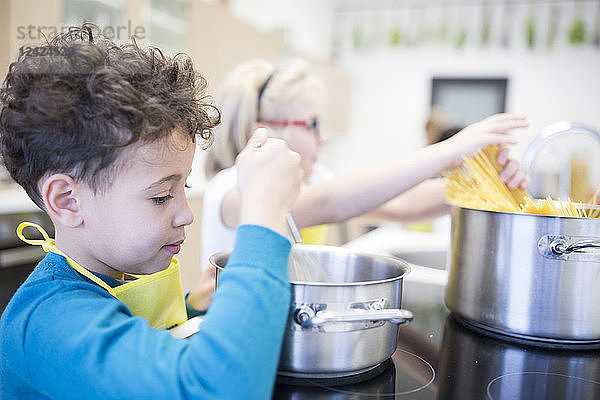 Pupils preparing pasta in cooking class