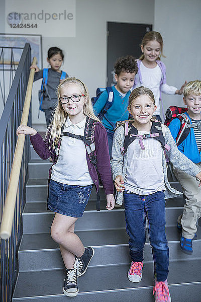 Happy pupils on staircase leaving school