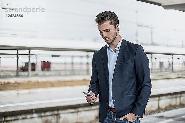 Businessman using cell phone at the platform