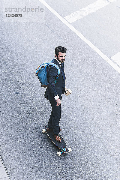 Businessman riding skateboard on the street
