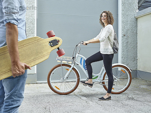 Man and woman with skateboard and bicycle