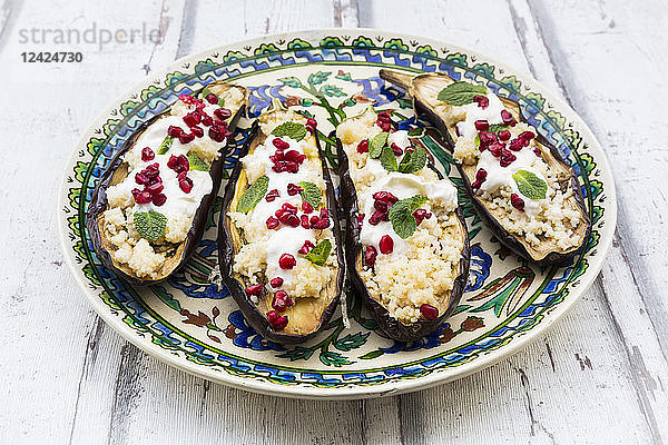 Filled aubergines with couscous  yogurt sauce  mint and pomegranate seeds