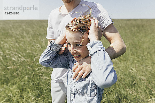 Happy boy and young man in a field