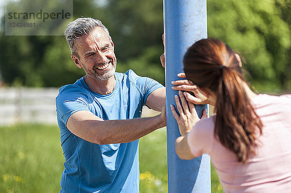 Couple doing stretching excersice on pole