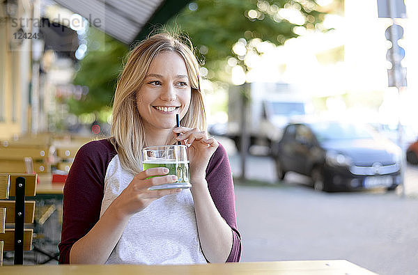 Blond young woman drinking 'Berliner Weisse' in beer garden