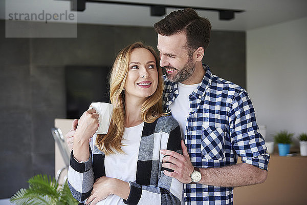 Happy man and pregnant woman moving into new flat