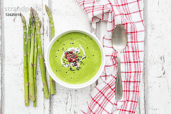 Green asparagus soup with pomegranate seeds and black sesame