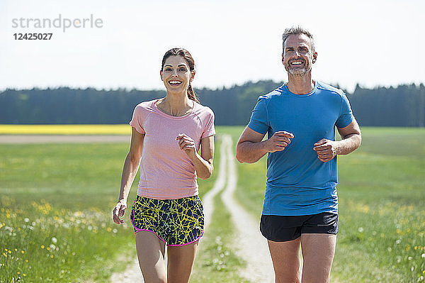 Couple running on field path