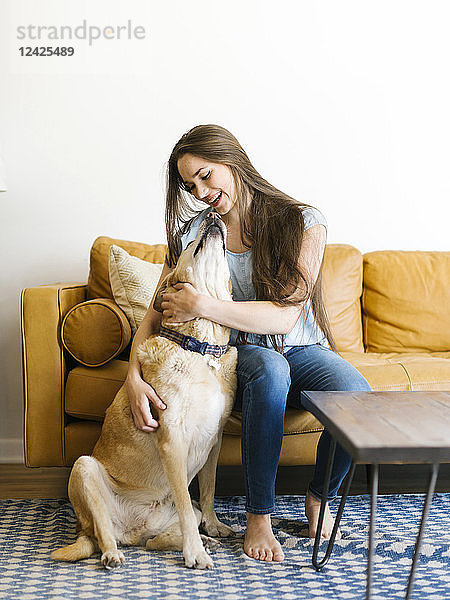 Frau auf Sofa mit Hund