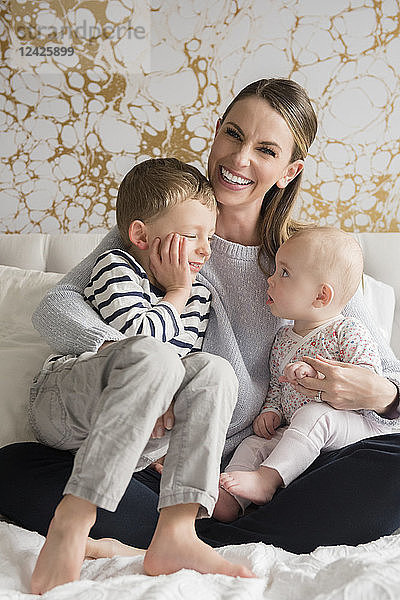 Porträt einer glücklichen Mutter von zwei Kindern (18-23 Monate  4-5)