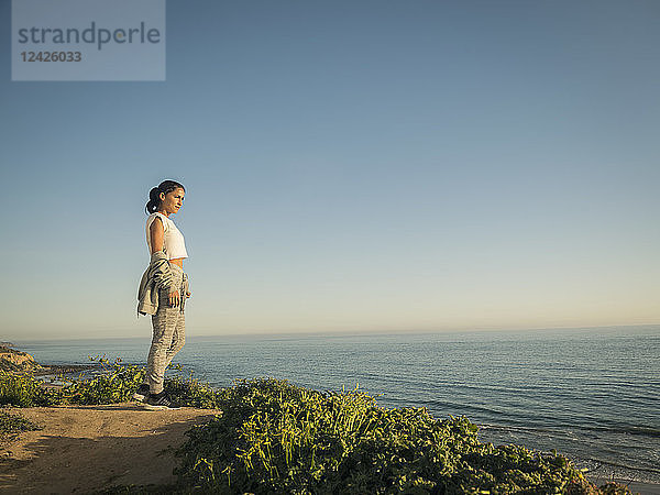 USA  Kalifornien  Newport Beach  Frau steht auf Klippe und schaut auf Aussicht