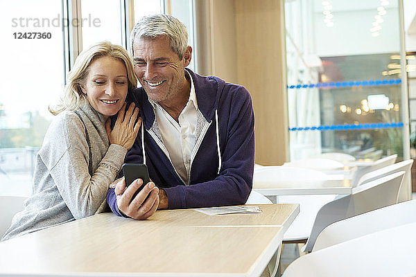 Pärchen benutzt Smartphone im Café