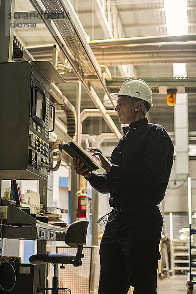 Fabrikarbeiter verwendet digitales Tablet in der Fabrik