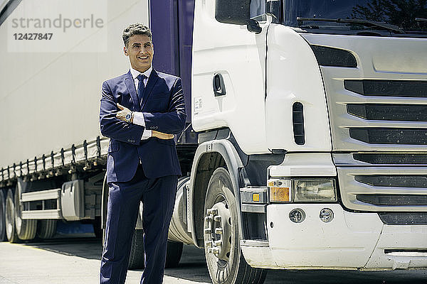 Geschäftsmann steht vor einem Lastwagen