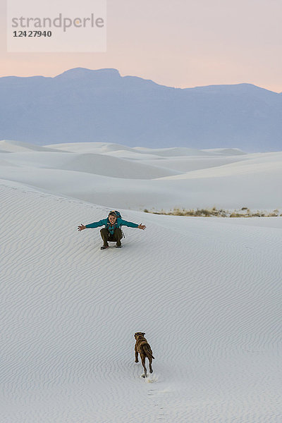 Frau spielt mit Hund beim Wandern in der Wüste des White Sands National Monument  Alamogordo  New Mexico  USA