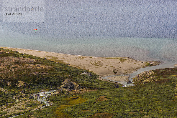 Fernblick auf einen Gleitschirmflieger nach einem Basejump vom Ulamertorsuaq  einem 1000 m hohen Granitturm im Tasermiut Fjord  Südgrönland