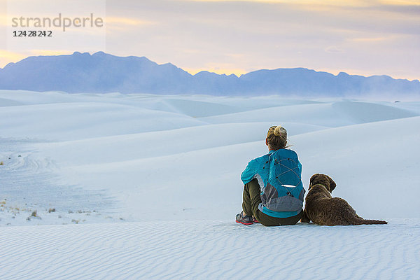 Rückansicht von Frau und Hund beim Wandern im White Sands National Monument  Alamogordo  New Mexico  USA