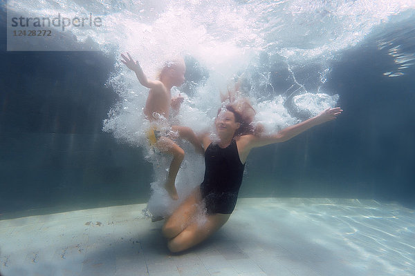 Unterwasseransicht von Mutter und Sohn beim Schwimmen im Schwimmbad