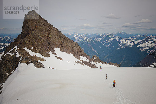 Fernblick auf drei Bergsteiger  die sich dem Foley Peak in der North Cascade Mountain Range nähern  Chilliwack  British Columbia  Kanada