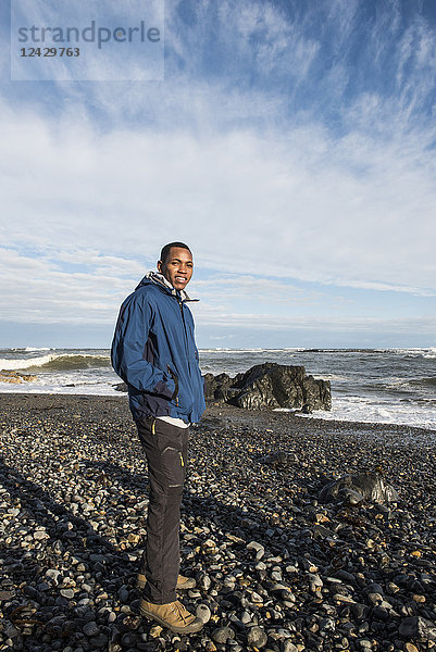 Porträt eines afroamerikanischen Mannes an einem felsigen Strand