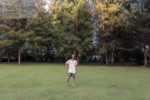 Frontansicht in voller Länge Porträt eines Mannes  der auf einer Wiese vor einem Wald steht  Banda Aceh  Sumatra  Indonesien
