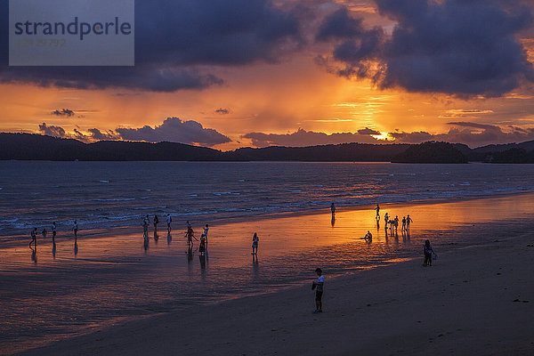 Menschen am Strand unter stimmungsvollem Himmel bei Sonnenuntergang  Krabi  Thailand