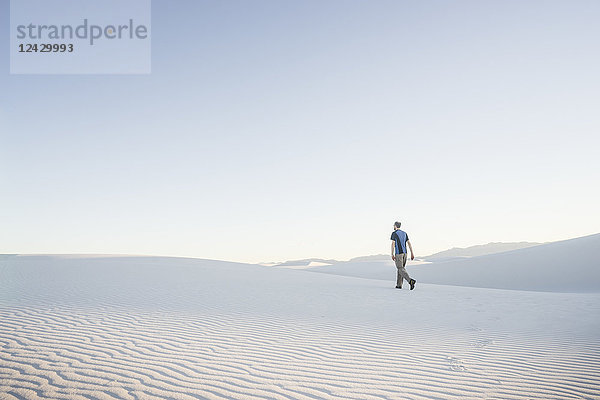 Fernblick auf einen einsamen Mann beim Wandern in der Wüste des White Sands National Monument  New Mexico  USA