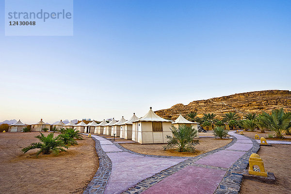 Zelte in einer Reihe mit zwei Wegen  im Bait Ali Camp  einem traditionellen arabischen Beduinenlager im Wadi Rum  einem geschützten Wüsten- und Nationalpark  mit Sandsteinbergen im Hintergrund  Akaba  Jordanien