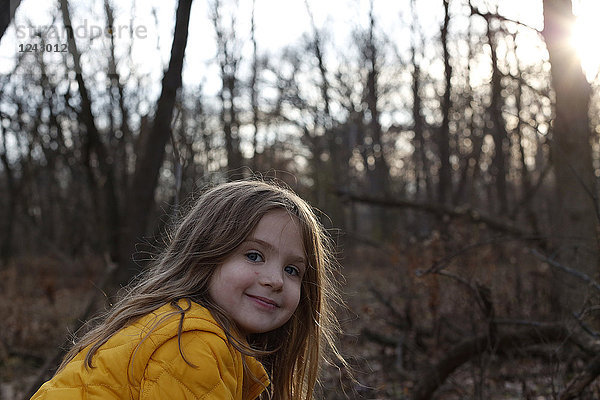 Kopfschuss eines lächelnden Mädchens  das in die Kamera schaut  im Wald