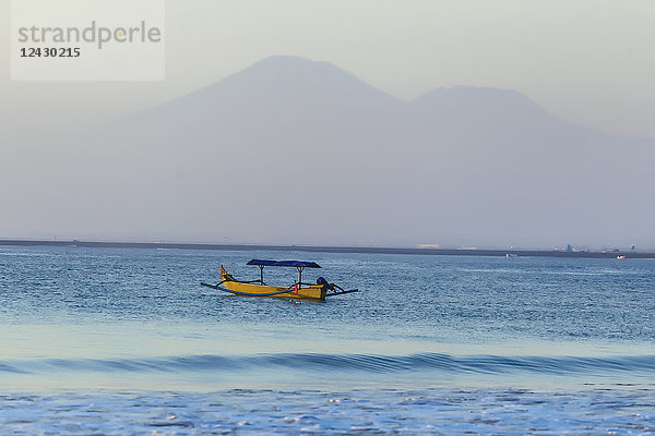 Boot im Meer vor Silhouetten von Bergen  Jimbaran  Bali  Indonesien