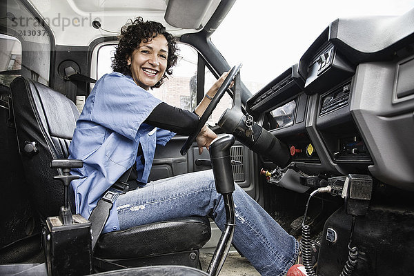 Hispanische Lkw-Fahrerin und Lieferwagen des Unternehmens.