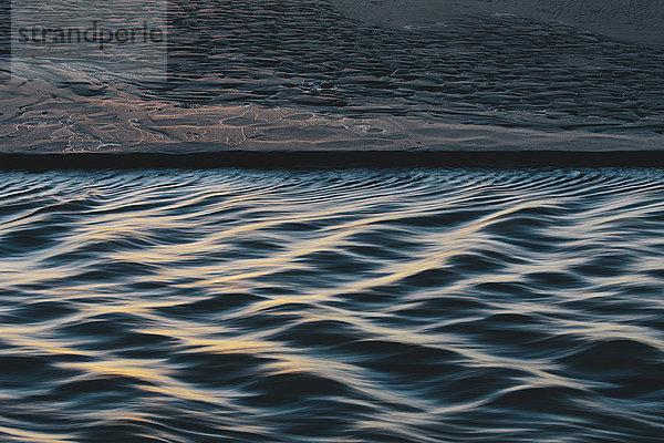 Detail des Sonnenlichts  das auf kleinen Wellen vom fließenden Strom reflektiert wird  Arcadia Beach State Park