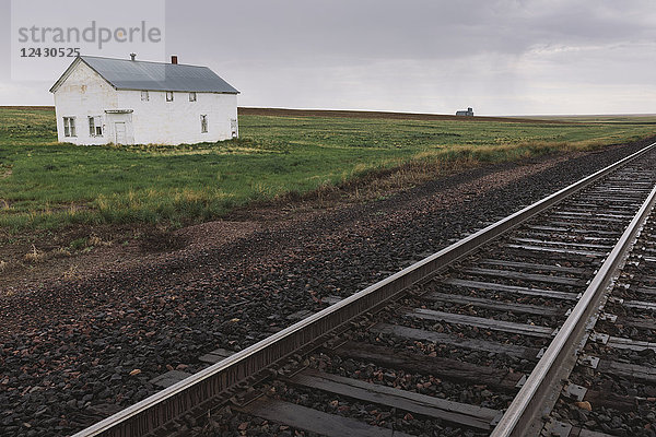 Verlassenes Bauernhaus in der Prärie  im Vordergrund Bahnschienen  Saskatchewan  Kanada.