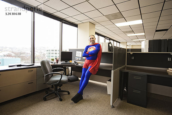 Ein selbstzufriedener kaukasischer Büro-Superheld in seiner Bürokabine.
