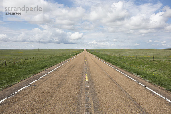 Offene Straße durch weite Prärie und Ackerland  Saskatchewan  Kanada.