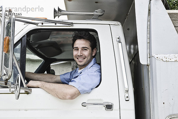 Kaukasischer Mann Lkw-Fahrer im Lkw-Fenster des Unternehmens.