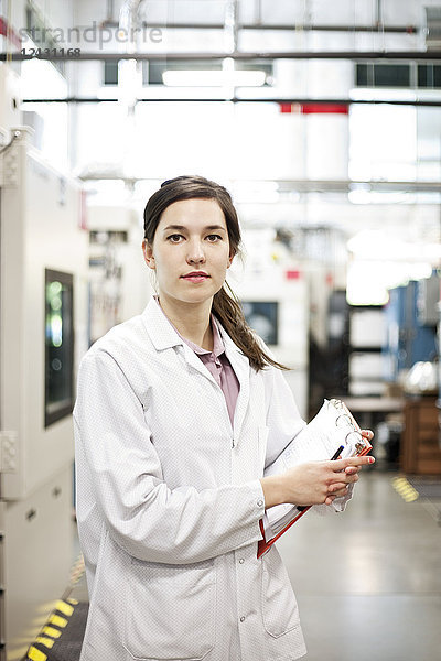 Ein Porträt einer kaukasischen Technikerin in einer technischen Forschungs- und Entwicklungsstätte.