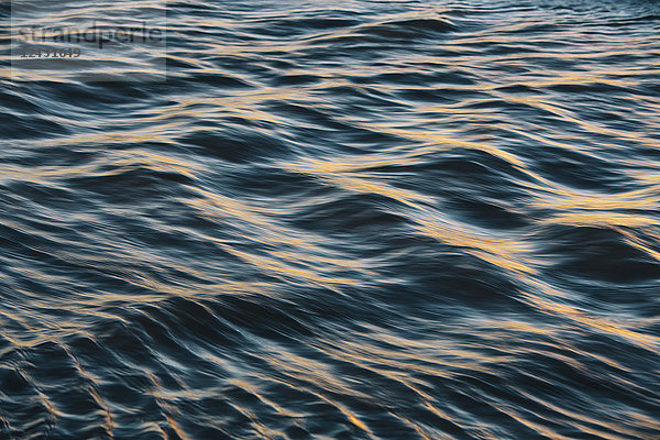 Detail des Sonnenlichts  das auf kleinen Wellen an der Wasseroberfläche reflektiert wird.