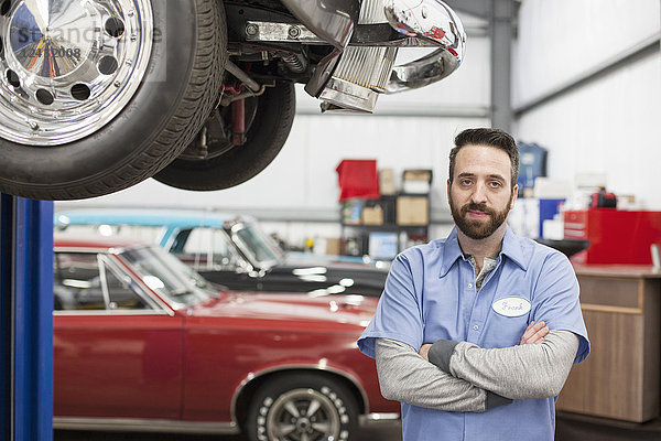 Ein Porträt eines kaukasischen Mechanikers in seiner Oldtimer-Werkstatt.