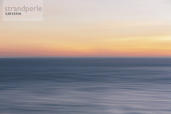 Blick in der Abenddämmerung aufs Meer über den Ozean  eine ruhige  wellige Meeresoberfläche.