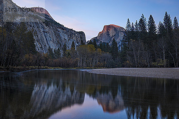 Der Half Dome fängt das letzte Licht des Sonnenuntergangs ein  das sich im Merced River im Yosemite-Nationalpark spiegelt  UNESCO-Welterbe  Kalifornien  Vereinigte Staaten von Amerika  Nordamerika
