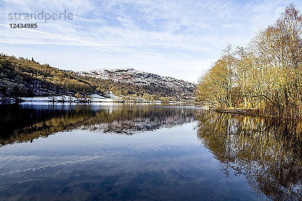 Eine perfekte Reflexion der schneebedeckten Berge und des Himmels im stillen Wasser von Grasmere  Lake District National Park  UNESCO-Weltkulturerbe  Cumbria  England  Vereinigtes Königreich  Europa