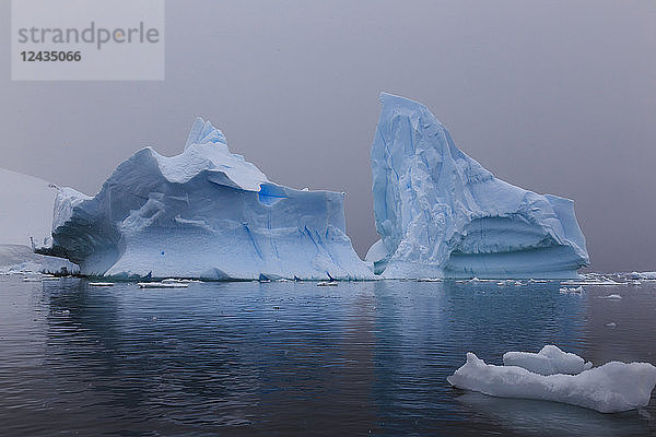 Blaue Eisberge bei schneereichem Wetter  vom Meeresspiegel aus  Waterboat Point  Paradise Bay  Graham Land  Antarktische Halbinsel  Antarktis  Polarregionen