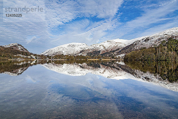 Eine perfekte Spiegelung der schneebedeckten Berge und des dramatischen Himmels im stillen Wasser von Grasmere  Lake District National Park  UNESCO-Weltkulturerbe  Cumbria  England  Vereinigtes Königreich  Europa