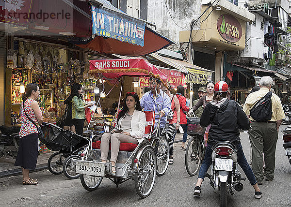 Ein Tourist in einem Cyclo auf einer belebten Straße in der Altstadt  Hanoi  Vietnam  Indochina  Südostasien  Asien