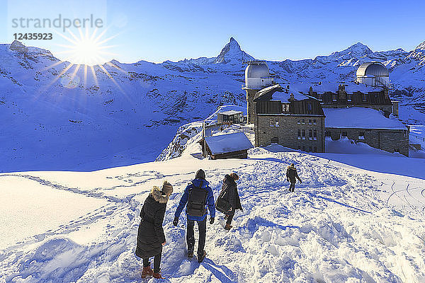 Touristen gehen im Schnee in der Nähe des astronomischen Observatoriums von Gornergrat  Zermatt  Kanton Wallis  Schweiz  Europa