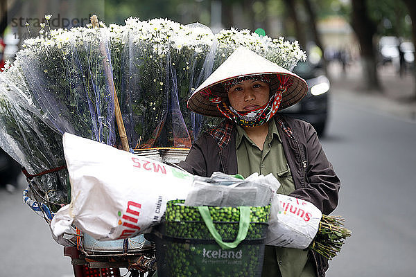 Verkäuferin verkauft Blumen von ihrem mobilen Fahrradladen aus  Hanoi  Vietnam  Indochina  Südostasien  Asien