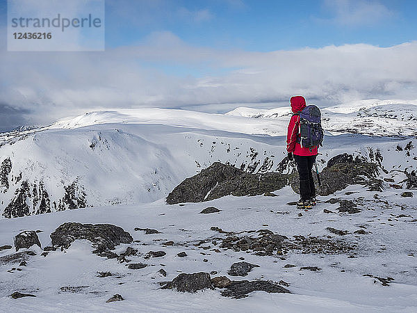 Ein Winterwanderer auf dem Gipfel des Cairnwell im Cairngorm National Park mit Blick auf Carn a' Gheoidh  Cairngorm National Park  Schottland  Vereinigtes Königreich  Europa