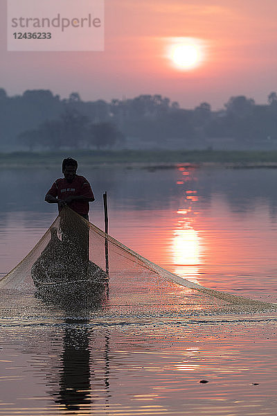 Fischer wirft sein Netz bei Sonnenaufgang am Taungthaman-See in der Nähe der U Bein-Brücke aus  Myanmar (Birma)  Asien